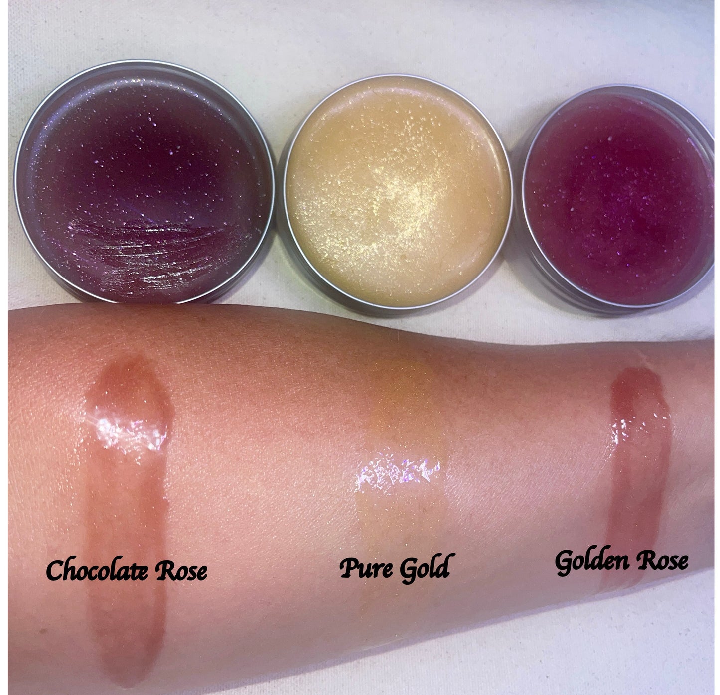 Three face balm tins with swatches on a person's arm labeled 'Chocolate Rose', 'Pure Gold', and 'Golden Rose'.